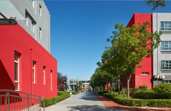 中关村第二小学红色教学楼与绿荫步道实景，锦连环校园建筑外墙色彩与环境建设