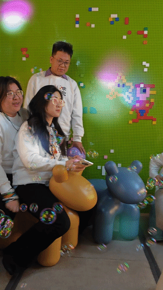 锦连环年会团队在彩色互动LED屏前骑充气玩具欢乐合影